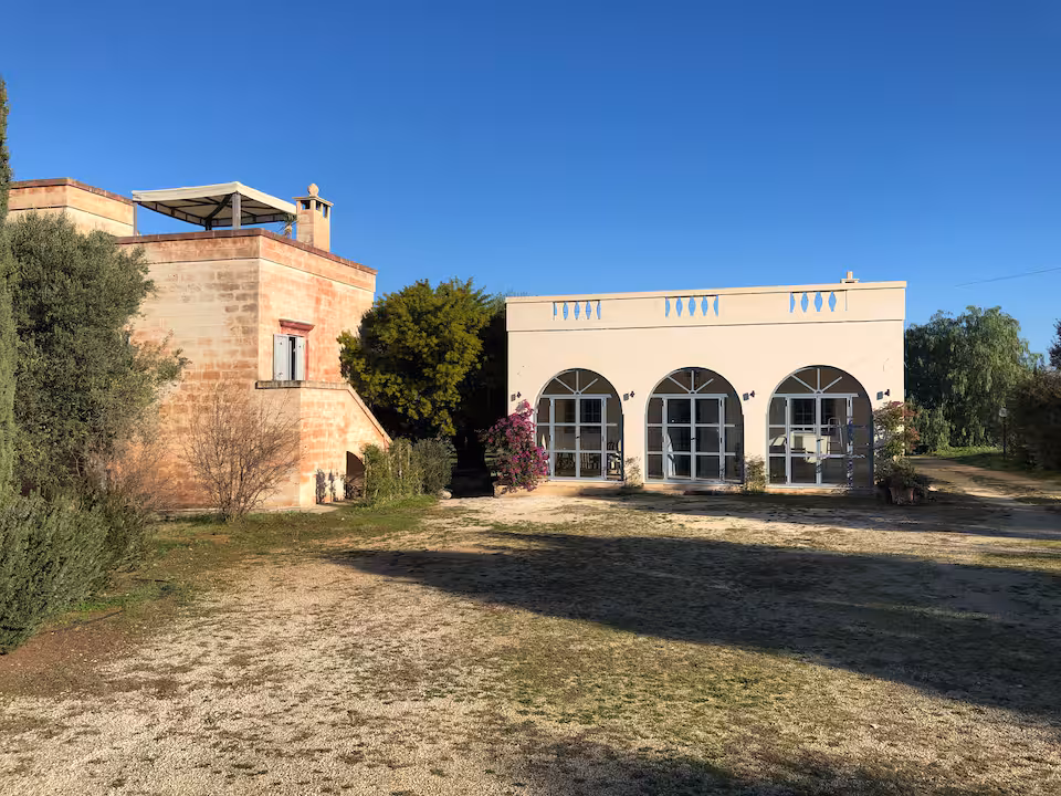 Gravel courtyard of Agriturismo San Virgilio showing the guest apartments building and the restored original farmer's house.